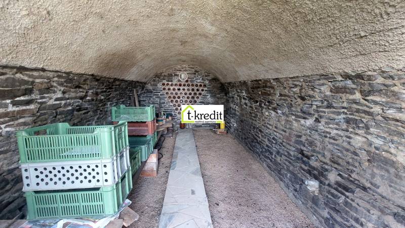 Steinkeller mit Regalen und Plastikkisten in den Weinbergen.