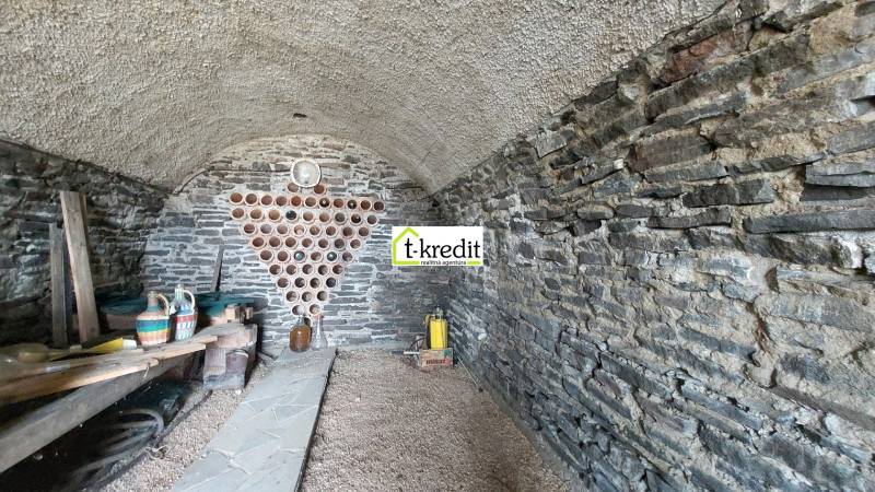Steinkeller im Weinberg mit Stauraum für Wein und Regal für Behälter.