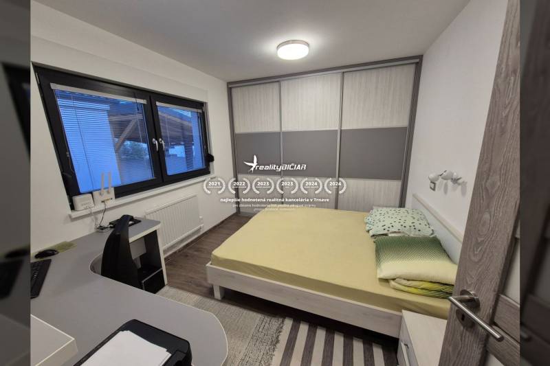 Schlafzimmer in einem Einfamilienhaus mit Bett, Schreibtisch und Schrank.