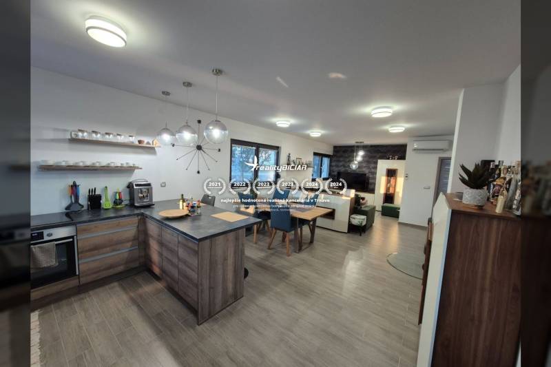 Küche und Wohnzimmer mit Holzboden in einem Einfamilienhaus.