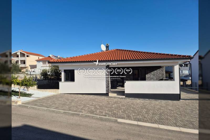 Ein Einfamilienhaus in der Mulo-Straße in Vrsi mit einem Terrakottadach und einem gepflasterten Hof.