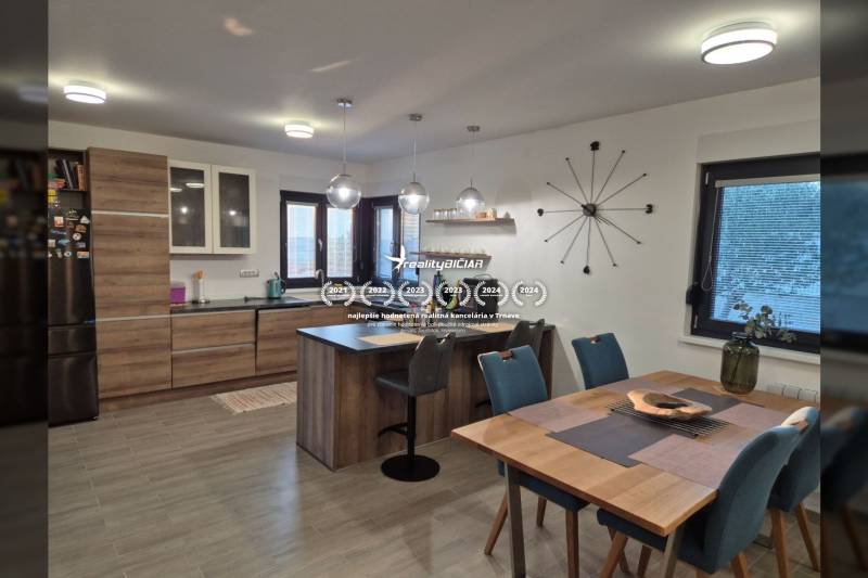 Küche eines Einfamilienhauses mit Holzboden, Tisch und Tafelgeschirr.