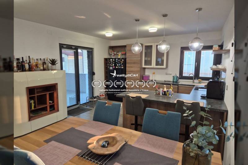 Küche in einem Einfamilienhaus mit Esstisch und Boden in Holzoptik.