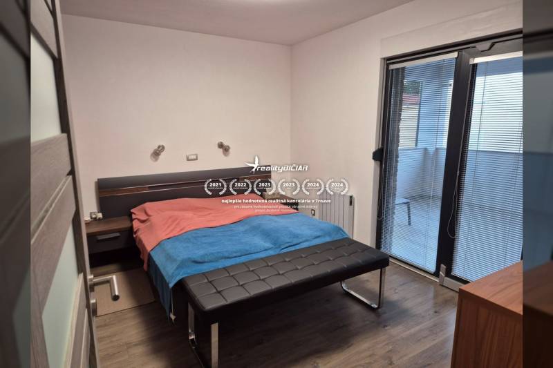 Schlafzimmer im Einfamilienhaus mit Holzboden und Zugang zum Balkon.