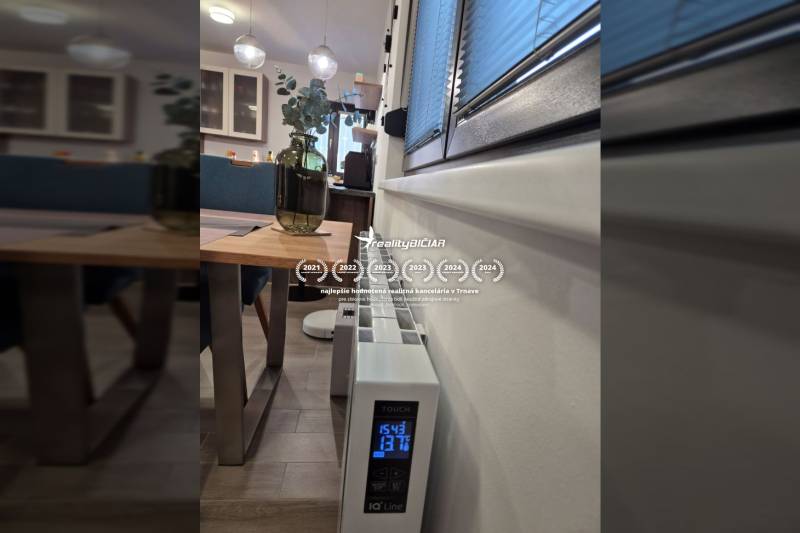 Innenraum eines Einfamilienhauses mit dekorativem Tisch, Heizgerät und Boden mit Holzdekor.