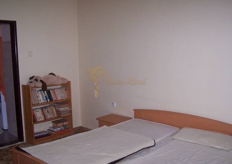 Schlafzimmer mit Bett und Bücherregal, ideal für eine Zweizimmerwohnung.