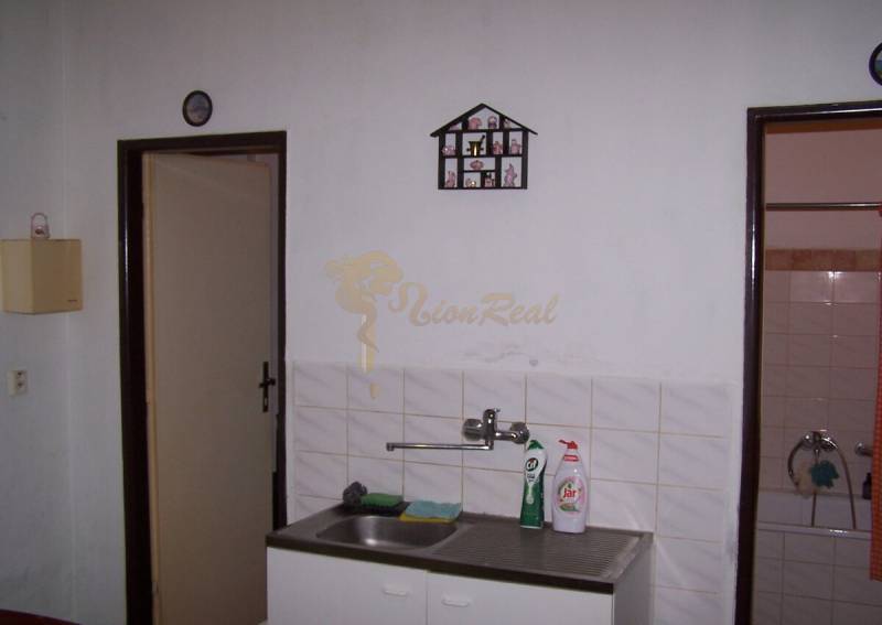 Küche mit hängendem Abtropfgestell neben dem Waschbecken in einer 2-Zimmer-Wohnung.