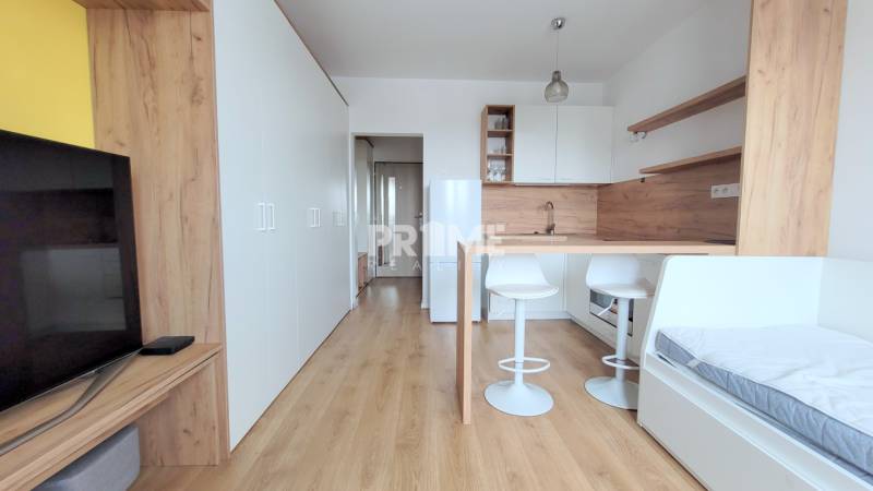 Einzimmerwohnung mit Kochnische, Bartresen und Boden mit Holzdekor.