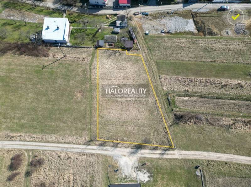 Baugrundstücke in Papradno, umgeben von Grünflächen und mit befestigter Straße.