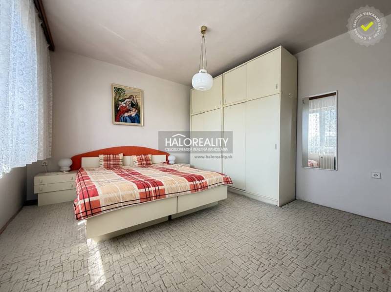 Schlafzimmer in einem Einfamilienhaus mit großem Schrank, Bett und Bild an der Wand.