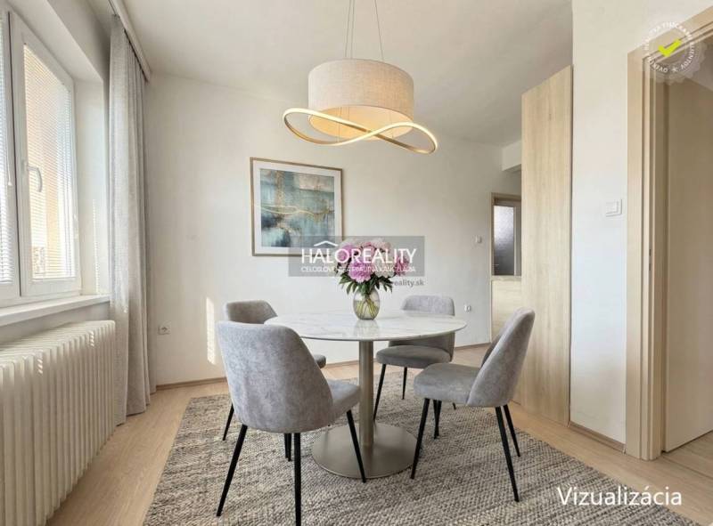 Essbereich in einem Einfamilienhaus mit rundem Tisch und eleganter Leuchte.