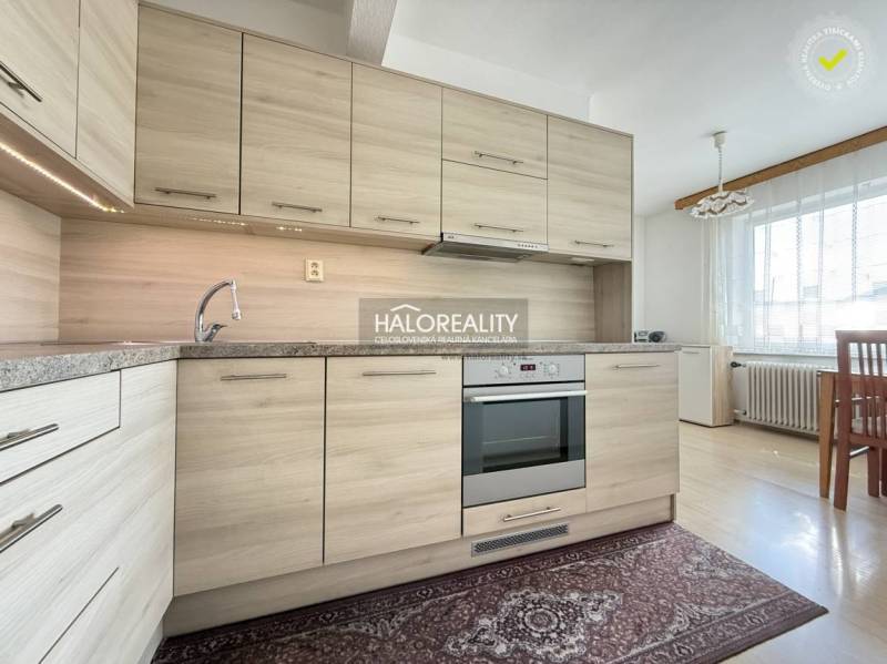 Eine Küche in einem Einfamilienhaus mit einem Boden in Holzoptik und einer modernen Küchenzeile.
