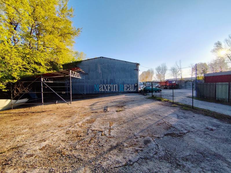 Industrieobjekt mit Parkplatz, umgeben von Bäumen in Nitra, geeignet für kommerzielle Nutzung.