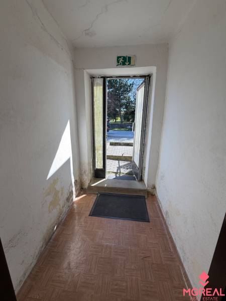 Ein Flur mit älteren Wänden und einem Boden in Holzoptik in einem Einfamilienhaus.