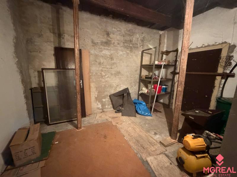 Úložný priestor v rodinnom dome s policami a náhodne uloženými predmetmi.