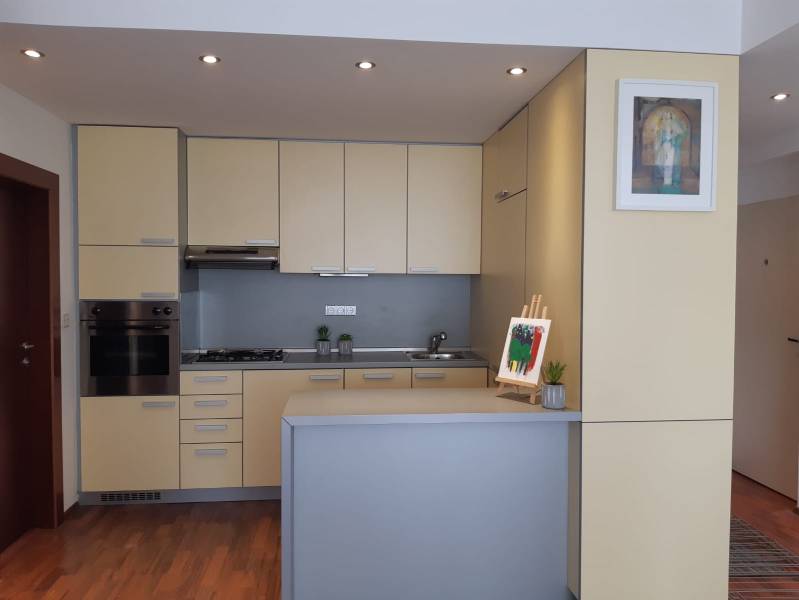 Küche in einer 3-Zimmer-Wohnung mit hellen Schränken und einem Boden in Holzoptik.