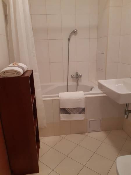 Badezimmer in einer 3-Zimmer-Wohnung mit Badewanne und weißen Fliesen.