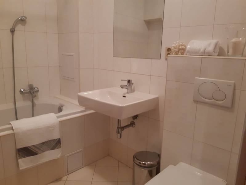 Badezimmer in einer 3-Zimmer-Wohnung mit Badewanne, Waschbecken und Toilette.
