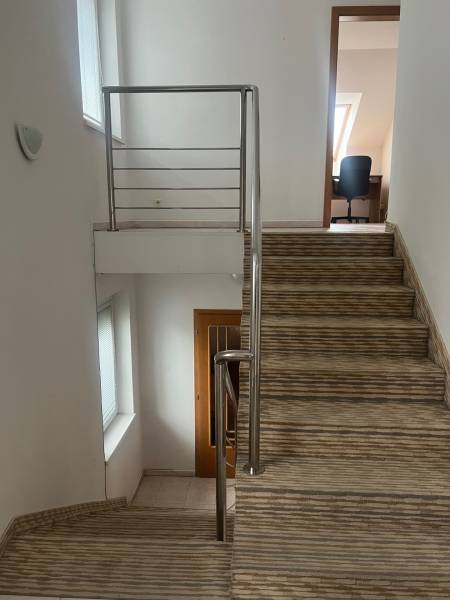 Die Treppe mit Geländer führt in das Zimmer im Einfamilienhaus, weiße Wände.