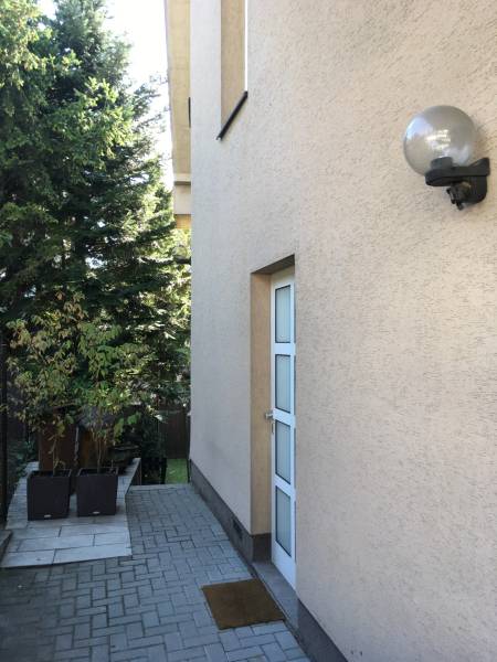 Ein Einfamilienhaus in der Mozartstraße in Bratislava - Altstadt mit gepflastertem Gehweg und Grünflächen.