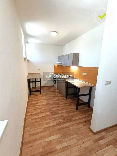 Küche in einer 2-Zimmer-Wohnung mit Holzboden und weißen Wänden.