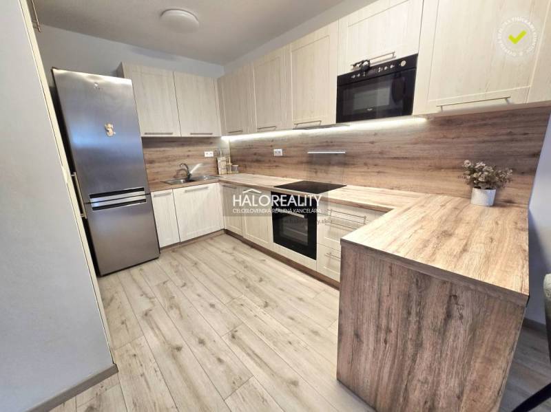 Küche mit Holzboden in einer 2-Zimmer-Wohnung mit moderner Küchenzeile.