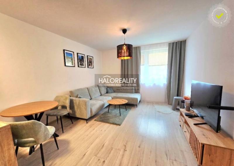 Helles Wohnzimmer in einer 2-Zimmer-Wohnung mit komfortablem Sofa und Boden in Holzoptik.