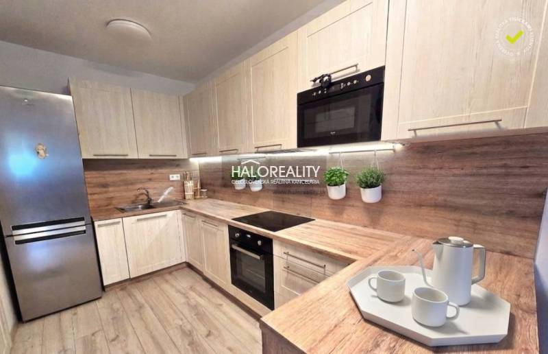 Moderne Küche in einer 2-Zimmer-Wohnung mit Holzdekor und eingebauten Geräten.