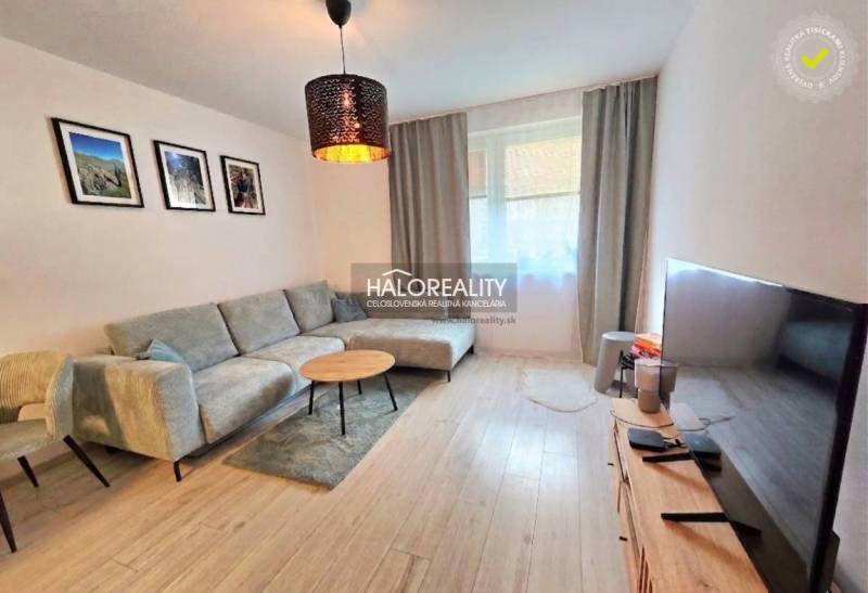 Wohnzimmer in einer 2-Zimmer-Wohnung mit Holzboden und bequemer Couch.