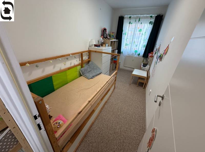 Kinderzimmer in einer 4-Zimmer-Wohnung mit Bett, Kommode und bunten Vorhängen.