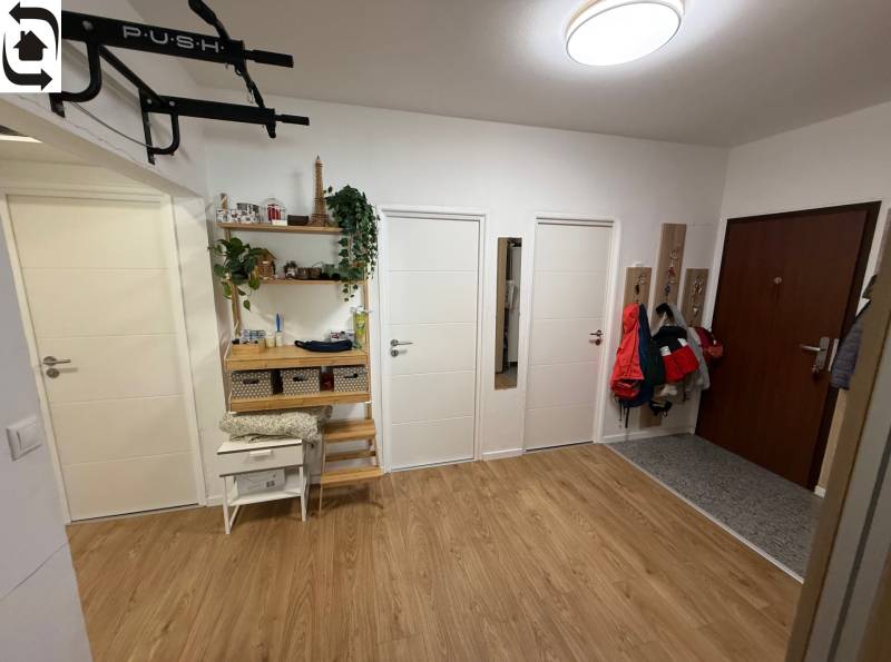 Eingangshalle mit vier Türen, Holzboden und Kleiderhaken in einer Vierzimmerwohnung.