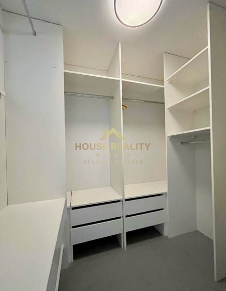 Ein Kleiderschrank mit weißen Einbauregalen und Schubladen in einer 3-Zimmer-Wohnung.