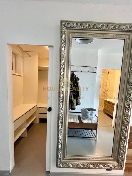 Ein Spiegel mit einem dekorativen Rahmen und einem geräumigen Ankleidezimmer in einer 3-Zimmer-Wohnung.