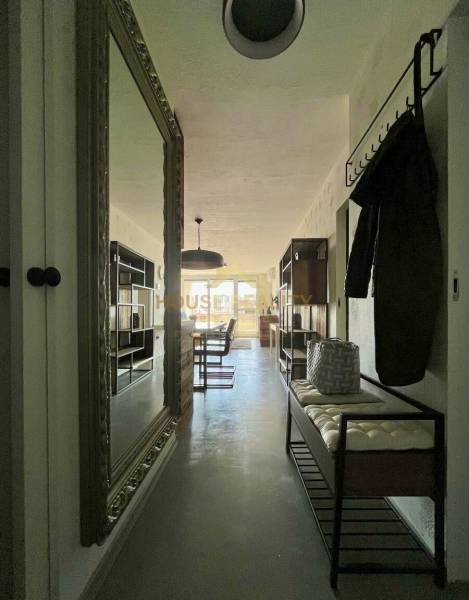 Ein Flur mit einem großen Spiegel, Kleiderhaken und einer Bank in einer 3-Zimmer-Wohnung.