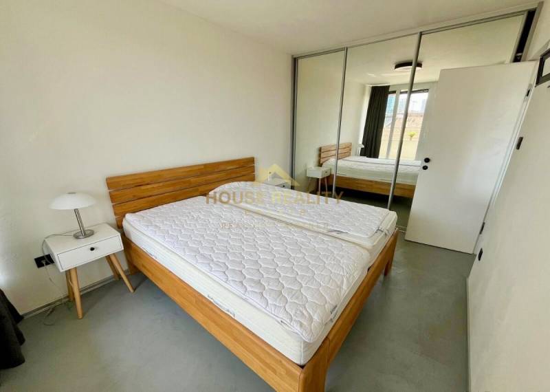 3-Zimmer-Wohnung mit Bett, Schrank, Nachttisch und Spiegeltüren.