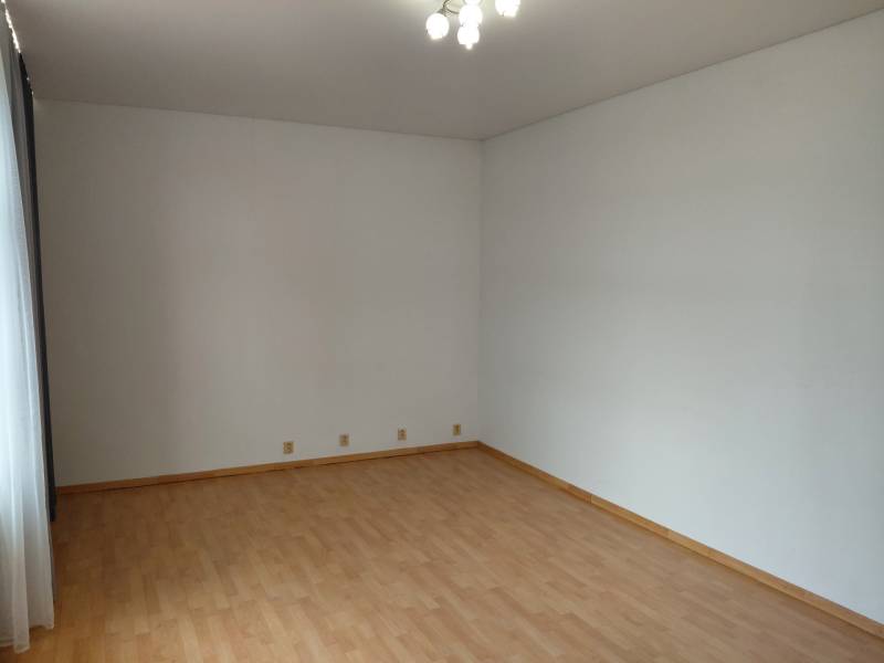 Geschäftsräume mit Holzboden, weißen Wänden und Beleuchtung.