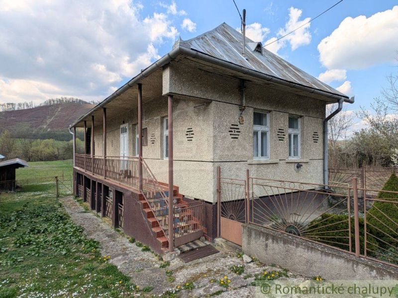 Ein Einfamilienhaus in Zubné mit einer Veranda und Treppen in einer natürlichen Umgebung.
