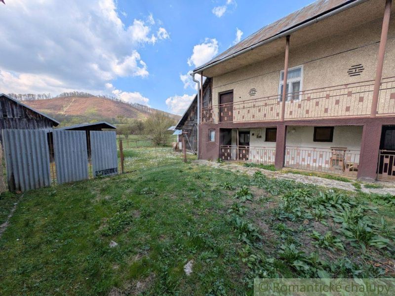 Ein Einfamilienhaus in Zubné mit einem grasbewachsenen Hof und Blick auf die Hügel.