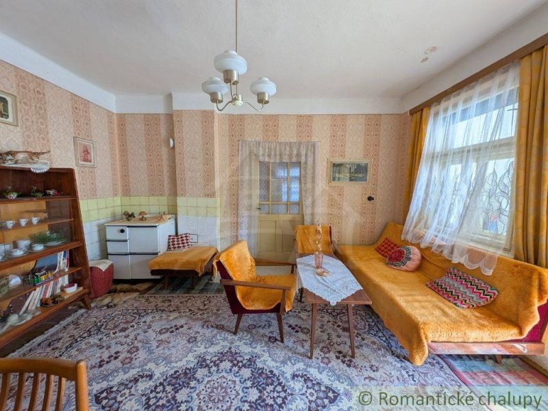 Wohnzimmer mit Retro-Möbeln, Teppich, Sofa und Tisch mit Decke.