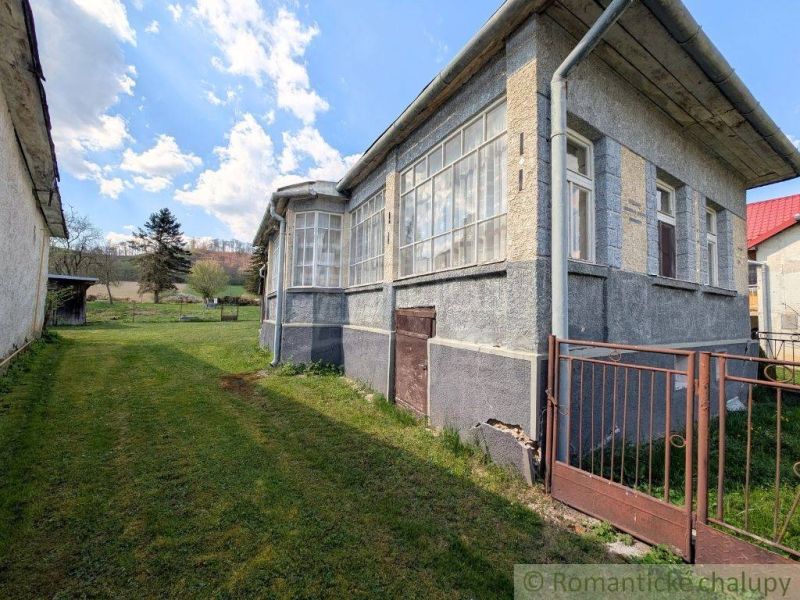 Ein Einfamilienhaus in Zubné mit angrenzendem Grundstück, Rasen und einer luftigen Veranda.
