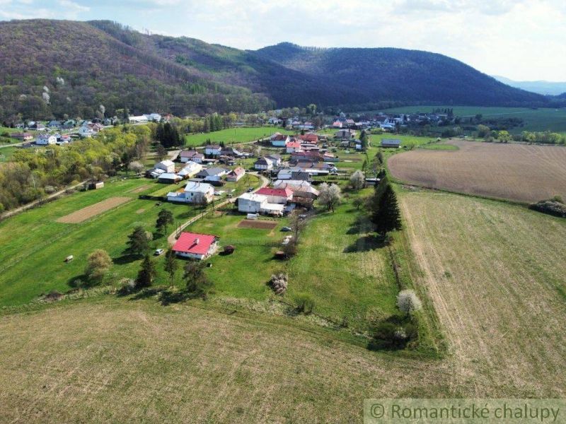 Luftaufnahme von Einfamilienhäusern in Zubné, umgeben von Feldern und Hügeln.