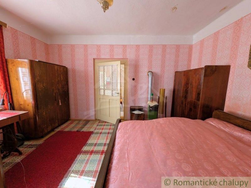 Ein Schlafzimmer in einem Einfamilienhaus mit Retro-Tapeten und Holzmöbeln.