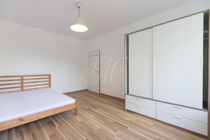 Schlafzimmer in einer 3-Zimmer-Wohnung mit Bett, Schränken und Boden mit Holzdekor.