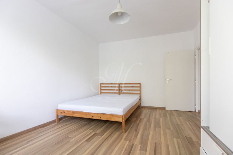 Schlafzimmer mit Bett und Holzboden in einer 3-Zimmer-Wohnung.