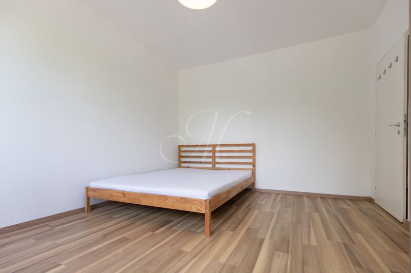Schlafzimmer mit Bett, Boden mit Holzdekor, in einer 3-Zimmer-Wohnung.