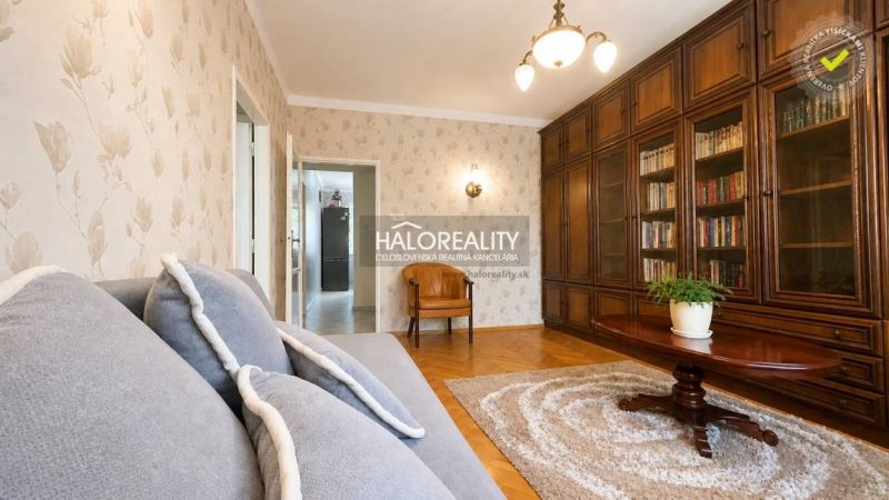 Wohnzimmer mit Bibliothek, Sofa und Holzboden in einer 3-Zimmer-Wohnung.
