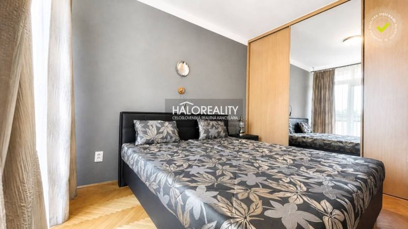 Schlafzimmer mit Doppelbett, Spiegelschrank und Holzboden in einer 3-Zimmer-Wohnung.