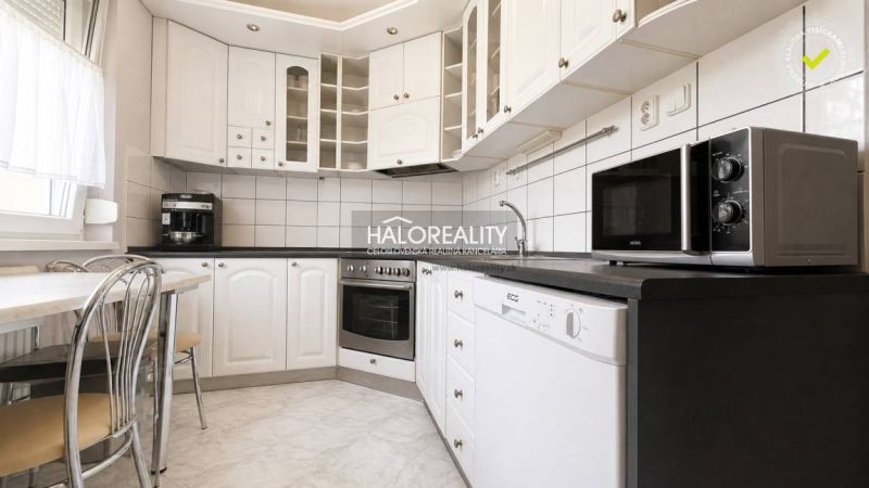 Küche in einer 3-Zimmer-Wohnung mit weißer Küchenzeile und Geräten.