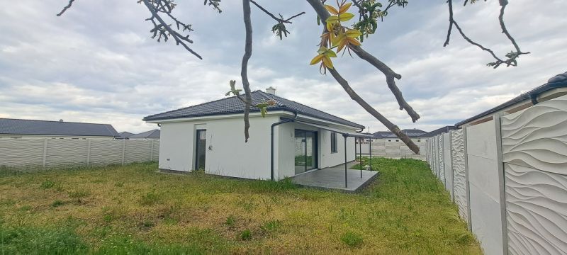 Ein Einfamilienhaus in Topoľnica mit Garten und Terrasse, umgeben von einem dekorativen Zaun.