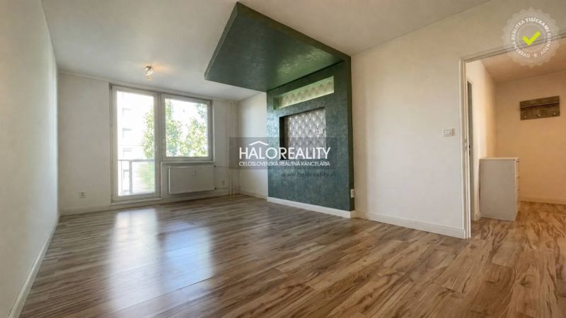 Wohnzimmer in einer 2-Zimmer-Wohnung mit Holzboden und großen Fenstern.